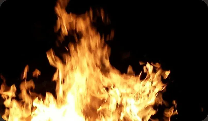 Flames of the evening bonfire against a dark sky