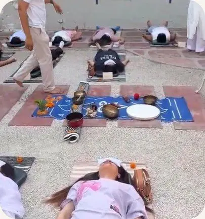 Yatri resting with eye covers around a cloth of singing bowls