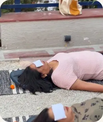 A Yatri lying still with an eye cover during shavasana